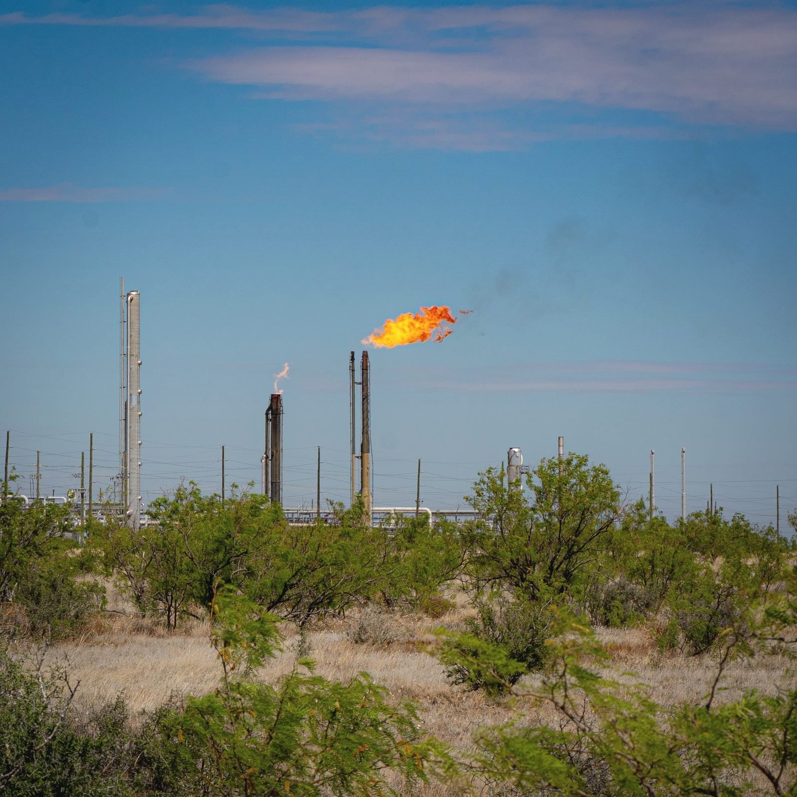 Flare stack burning above mesquite scrub near Midland, Texas