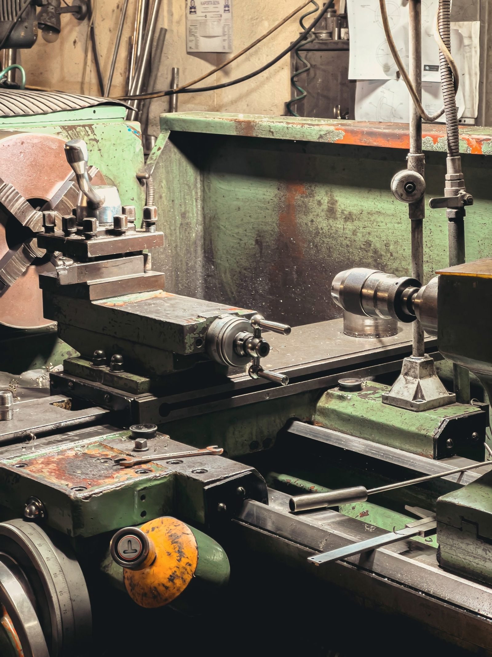 Close view of a green lathe carriage and chuck
