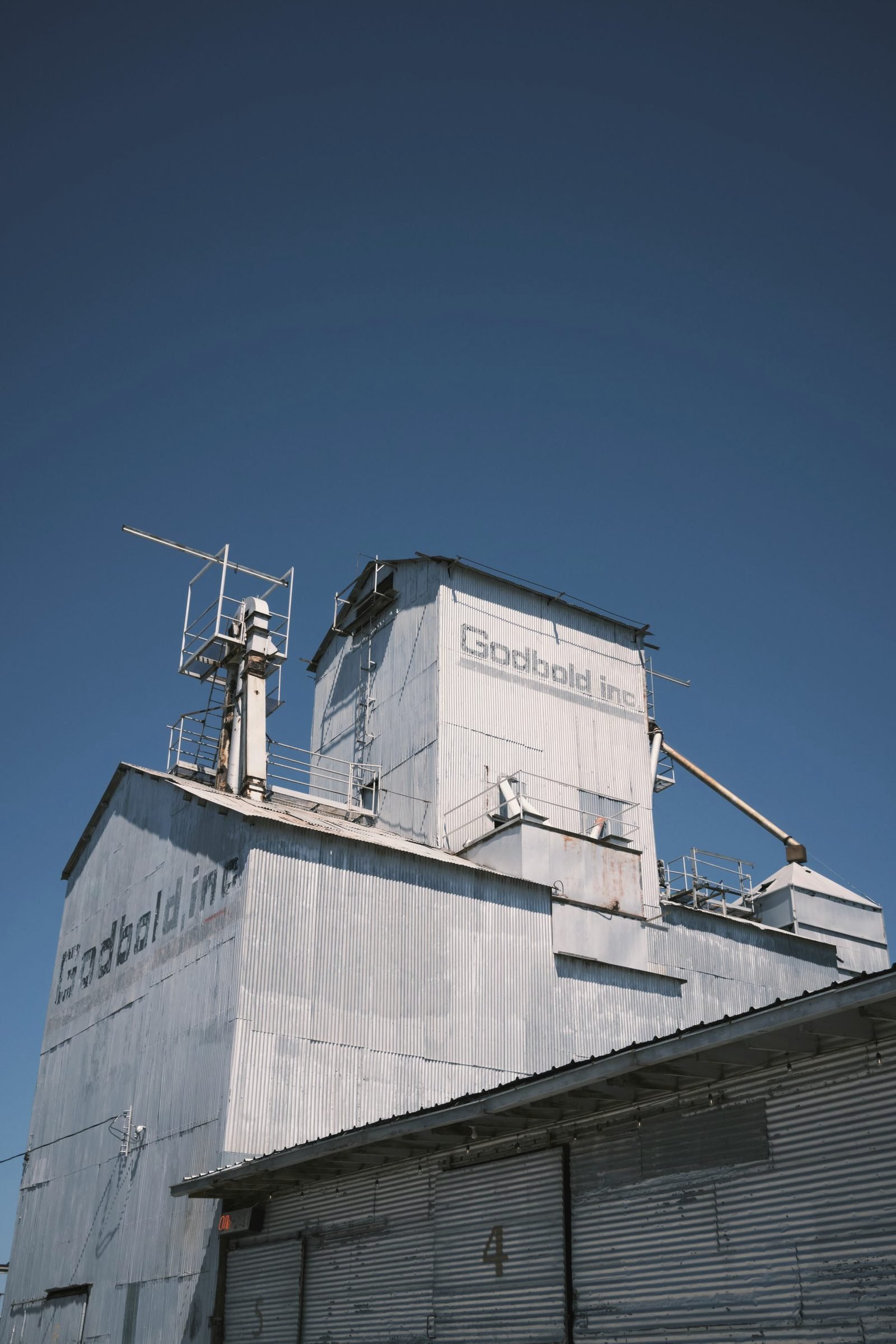 Corrugated metal industrial building against a deep blue sky